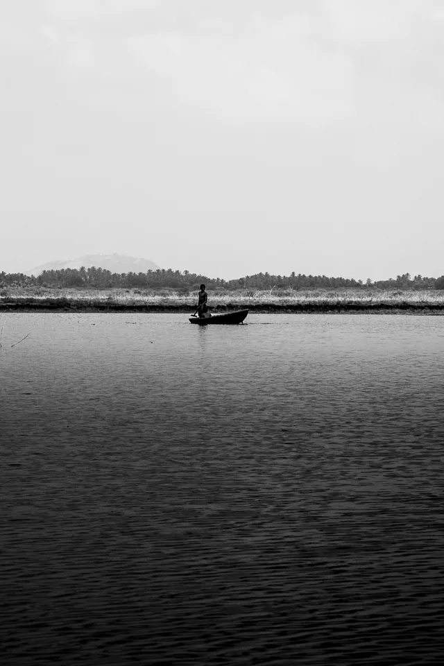 A wide, glassy lake, a far hill and the smallest signs of life: almost nothing, beautifully held.